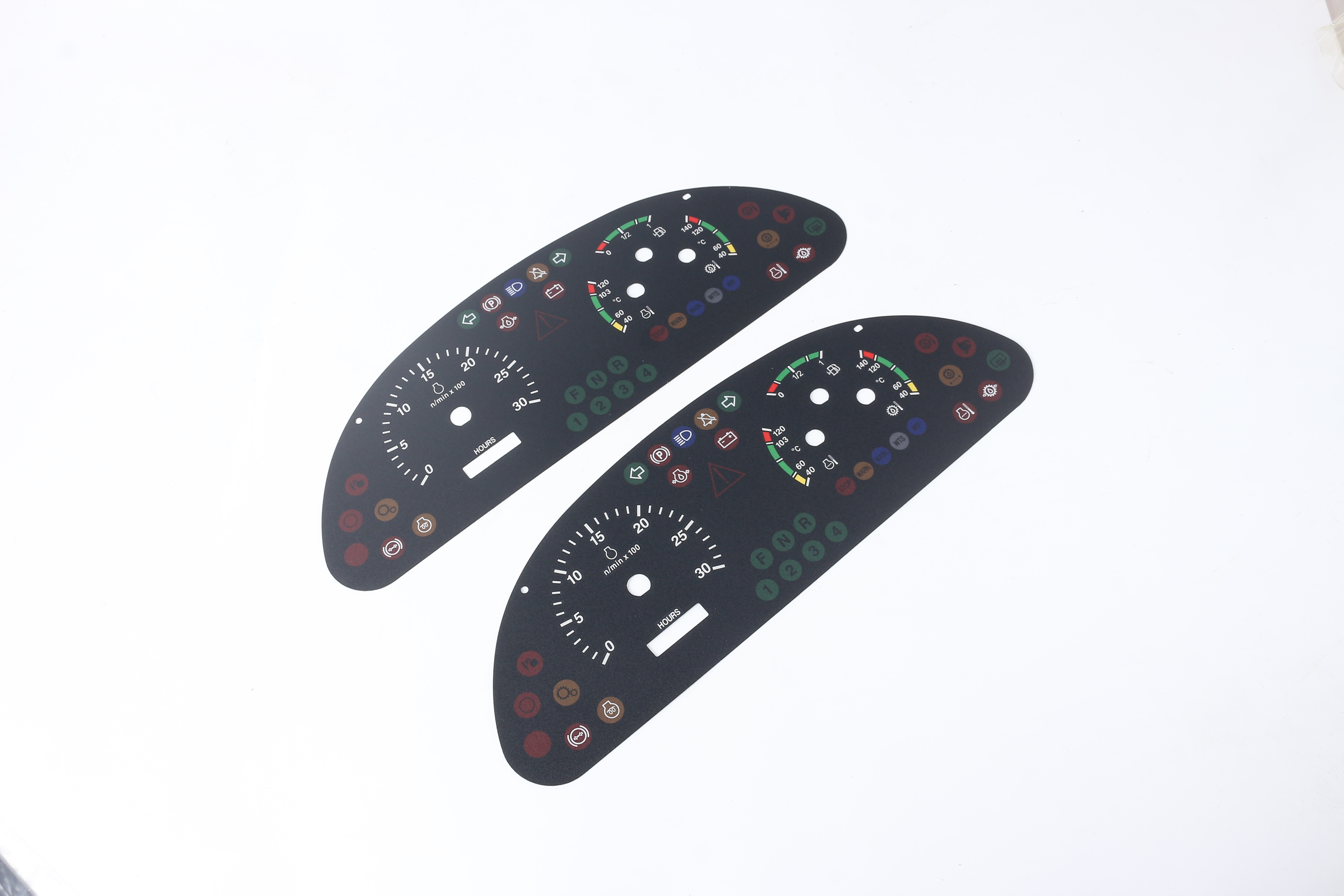 Two complete black automotive instrument overlays with gauge scales, indicator legends, apertures and mounting holes